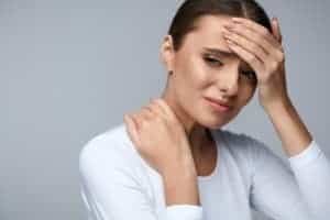 woman in pain looks upset before getting online therapy for chronic pain with a Synergy etherapist. 
