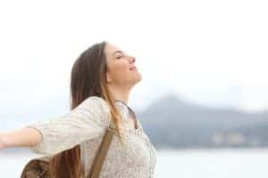 Young woman taking a moment in her day to breathe and zone in | Online therapy for anxiety | Synergy eTherapy