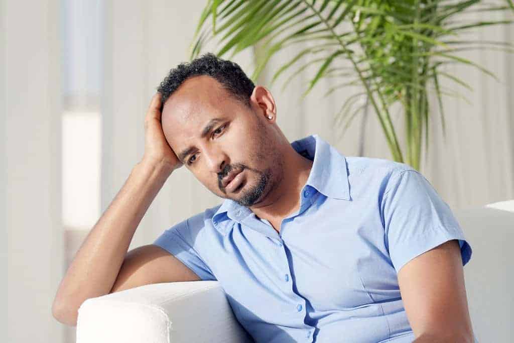 depressed man at home before meeting with a Synergy eTherapy therapist for online depression treatment and counseling