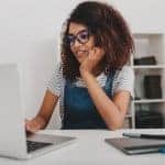 Black woman on a laptop during online therapy in Maine with an online anxiety therapist with Synergy eTherapy an online counseling practice offering online couples counseling, 